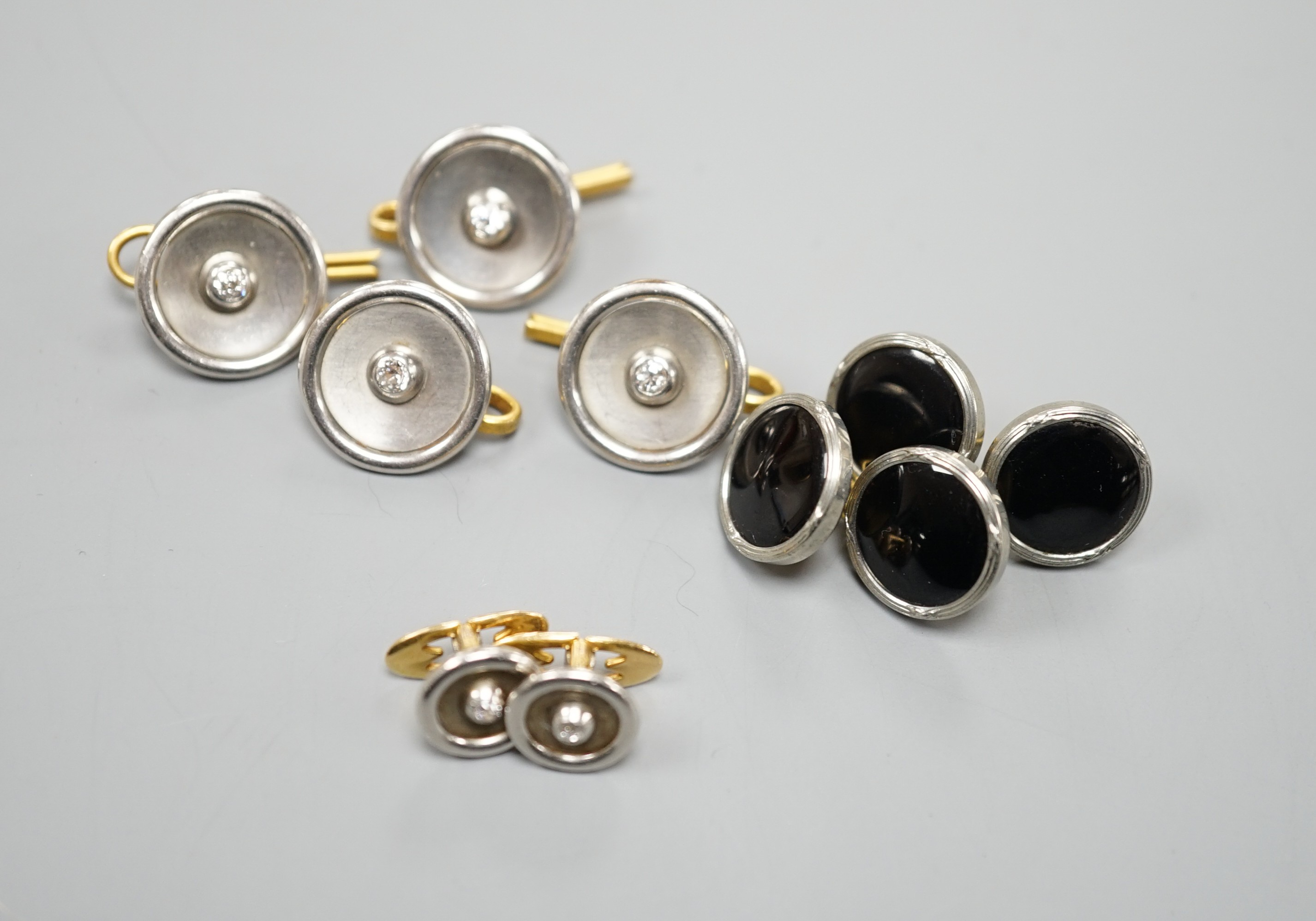A pair of small pair of yellow and white metal diamond set cufflinks and four similar dress studs and four other yellow metal and black enamel? dress studs, gross weight 22.6 grams